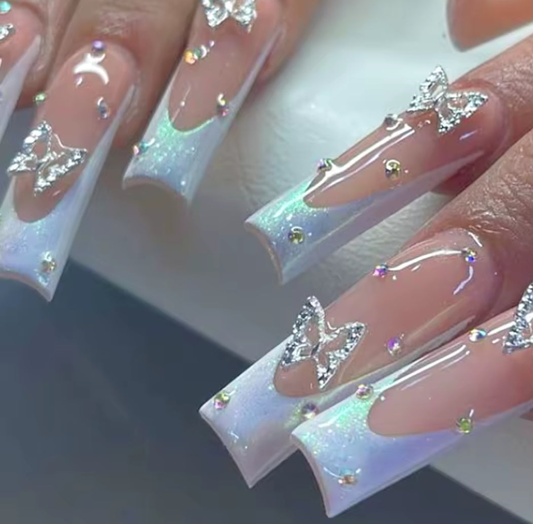 Uñas coquetas con mariposas blancas